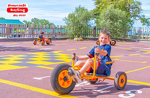 Niño sonriente karting a pedales en camping CAPFUN Pachy FOSSES LA VILLE.