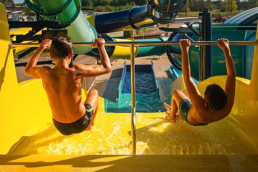 Ni�os bajando por un gran tobog�n acu�tico amarillo en el camping CAPFUN Pachy en FOSSES LA VILLE.