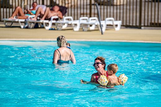 Piscina exterior con mujer y niño en el camping CAPFUN Pachy en FOSSES LA VILLE.