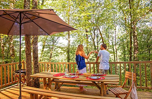 Pareja en terraza de alojamiento en el camping VAGUES OCEANES Paille Basse en Souillac (46).