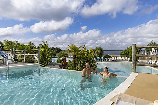 Piscina exterior con adultos relaj�ndose en el camping CAPFUN Paillotte en AZUR (40).