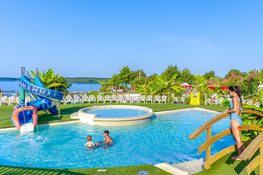 Piscina exterior con tobogán acuático y piscina infantil en el camping CAPFUN Paillotte en AZUR (40).