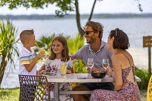 Familia cenando en el restaurante del camping CAPFUN Paillotte en AZUR (40).