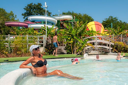 Piscina exterior con toboganes acuáticos y juegos de agua en el camping CAPFUN Paillotte en AZUR (40).