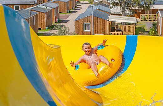 Tobogán acuático amarillo con niño en camping CAPFUN Palais de Gaufrette (57).