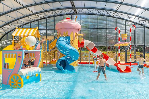 Zona de juegos acu�ticos cubierta con toboganes en el camping CAPFUN Palais de Gaufrette en R�mering les Puttelange (57).