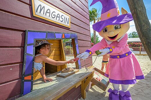 Niña jugando con la mascota en la tienda de juegos, en el camping CLICOCHIC Palmira Beach en Vendres-Plage (34).