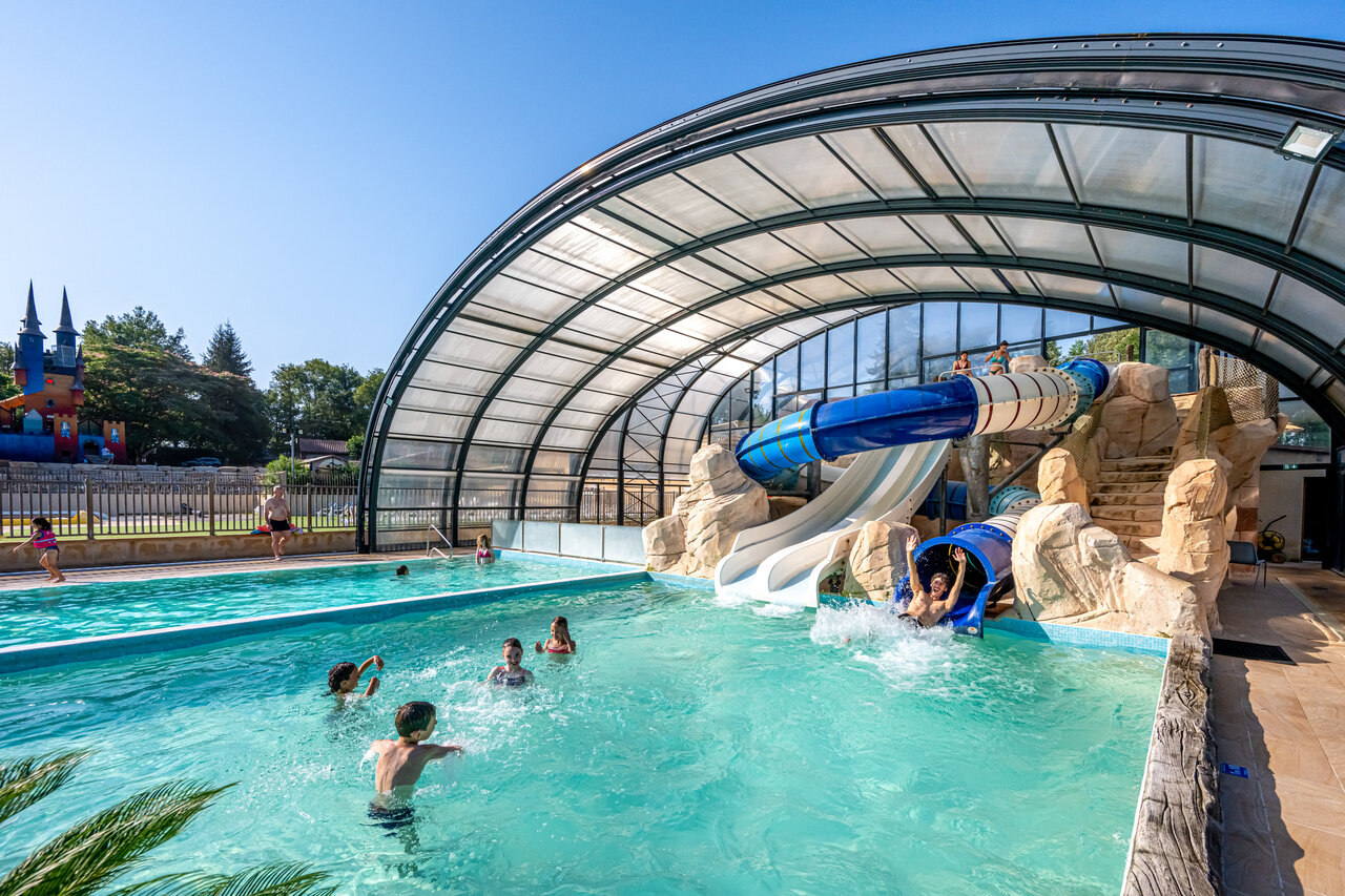 Piscina cubierta con toboganes acu�ticos y ni�os jugando en camping CAPFUN Palombi�re en Sarlat (24).