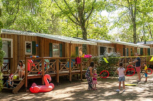 Mobil-homes de madera, familias jugando en el camping CAPFUN Palombière, SAINT-NATHALENE (24).