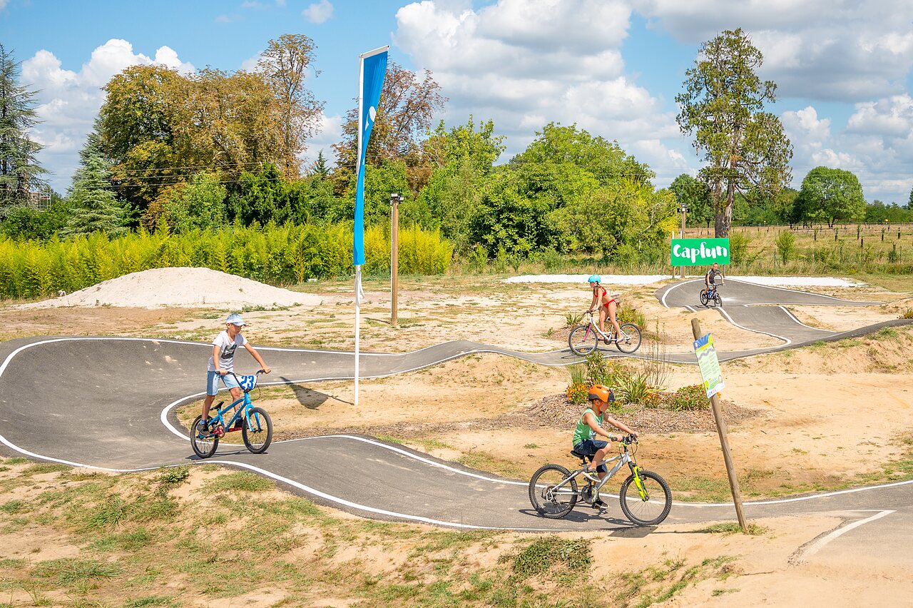 Pista de pumptrack y ni�os en bicicleta en el camping CAPFUN Paradis de Bazas en BAZAS (33).