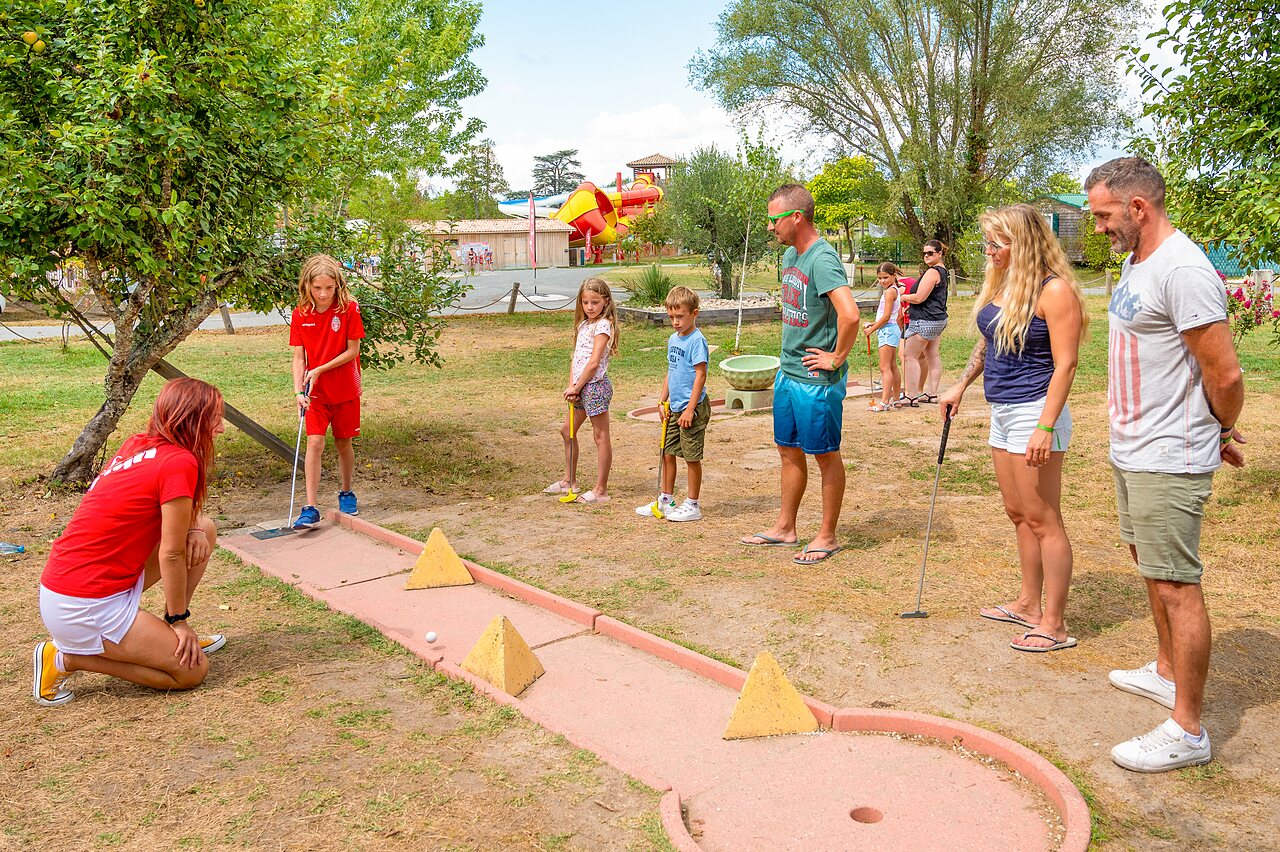 Familia y ni�os jugando minigolf con animador en el camping CAPFUN Paradis de Bazas en BAZAS (33).