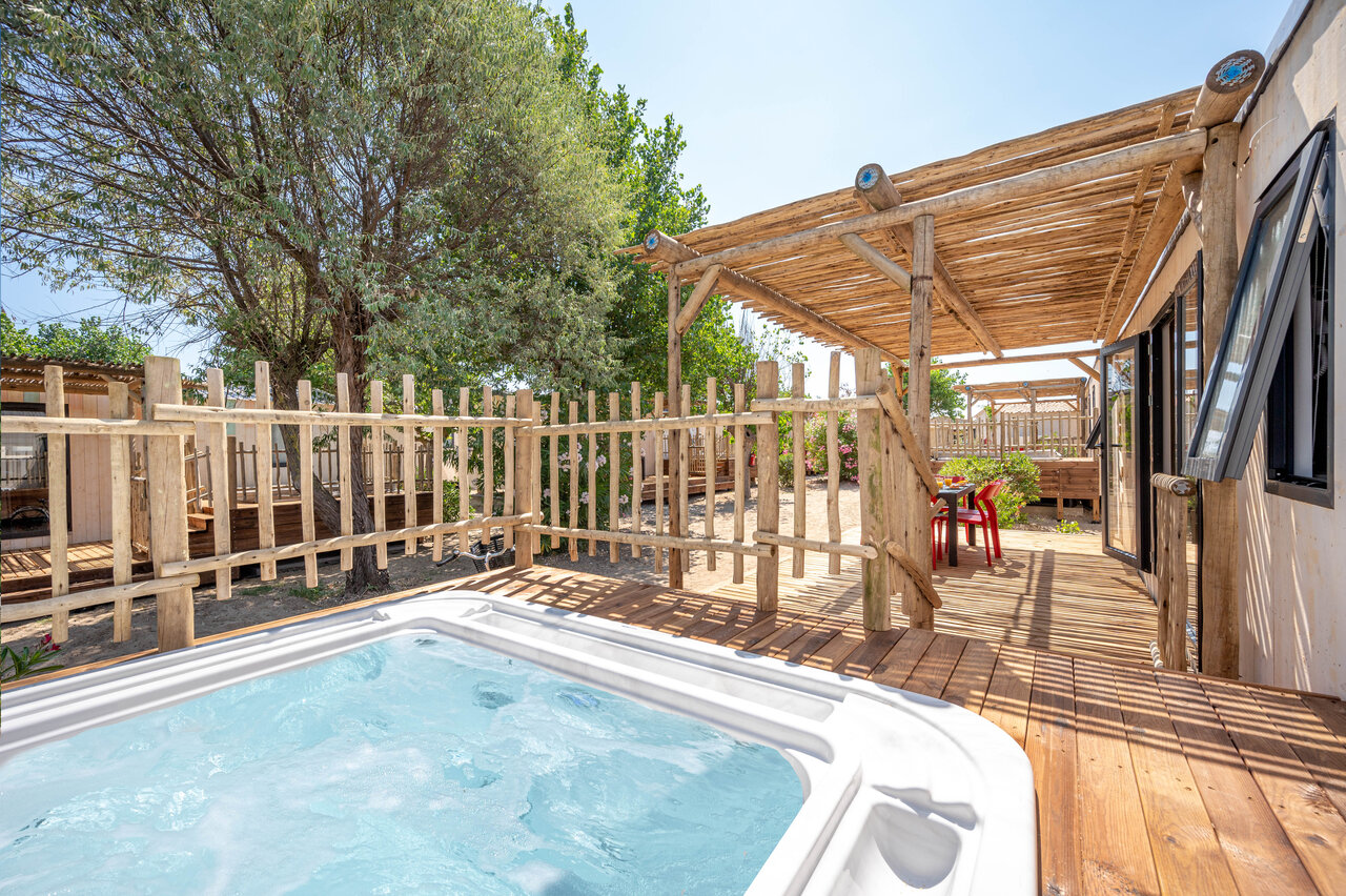 Jacuzzi privado y terraza de madera de un Mobil-home en camping CLICOCHIC Paradou.