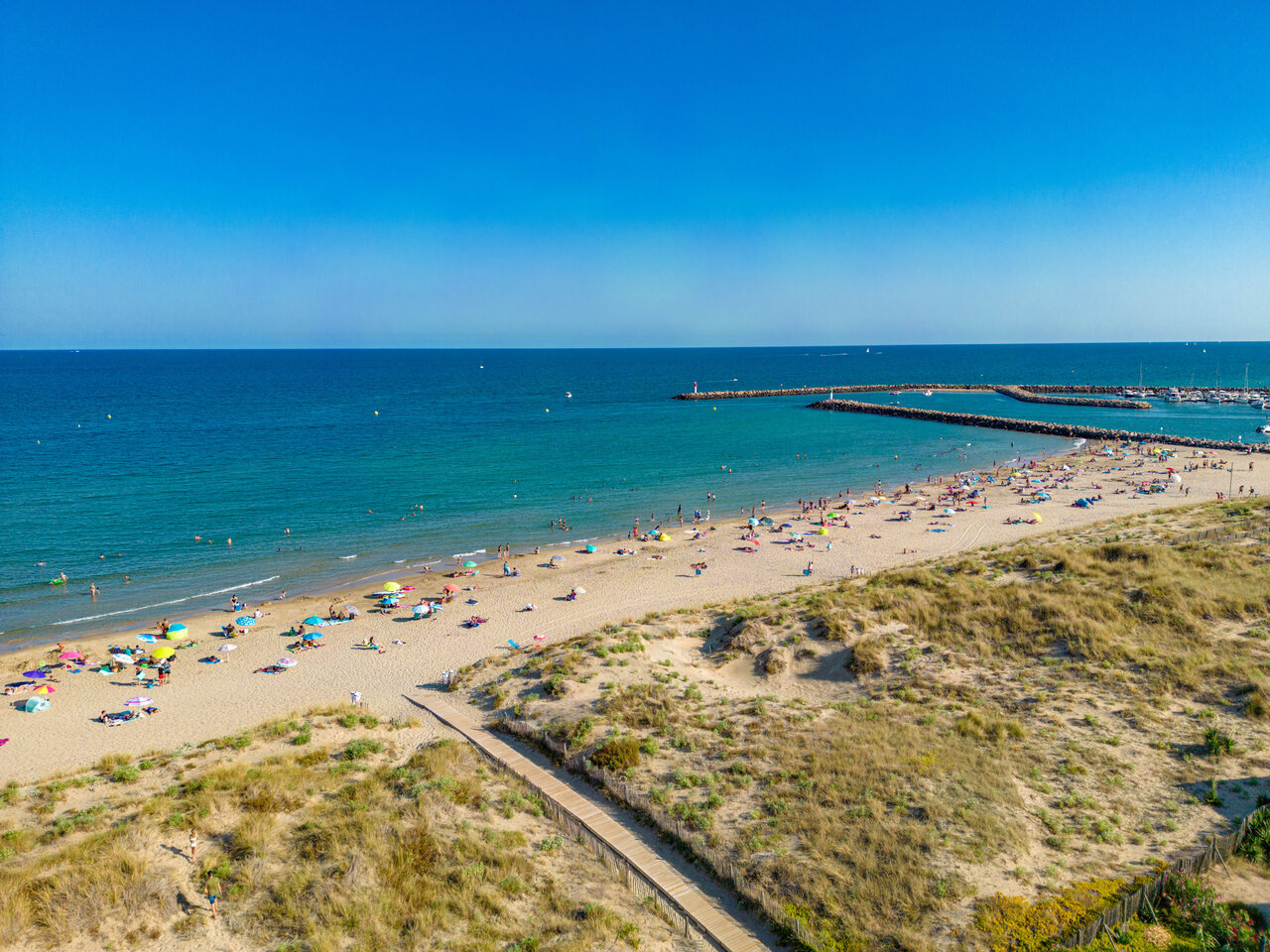 Playa de arena fina, ba�istas y puerto deportivo en el camping CLICOCHIC Paradou.