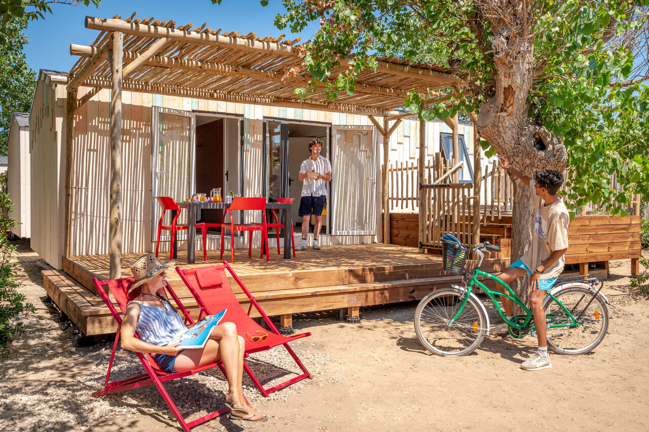 Mobil-home moderno, terraza sombreada, familia en camping CLICOCHIC Paradou en Marseillan-Plage.