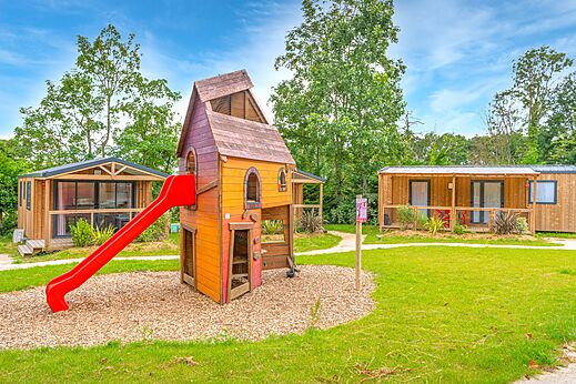 Zona de juegos con tobogán y Mobil-homes modernos en el camping CAPFUN Parc de Paris en Villevaudé (77).