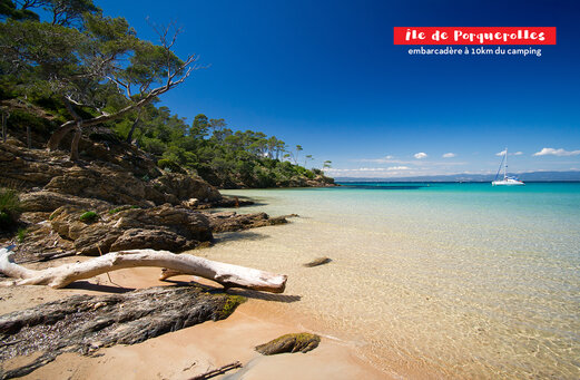 Playa de arena fina, aguas turquesas y velero cerca de la Isla de Porquerolles.