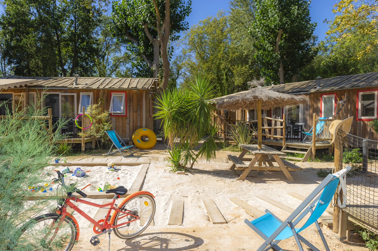 Mobil-homes de madera, arenero, bicicleta en el camping CAPFUN Paris Roussillon en ARGELES SUR MER.