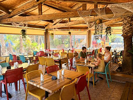 Restaurante familiar con mesas coloridas en el camping CAPFUN Paris Roussillon en ARGELES SUR MER (66).