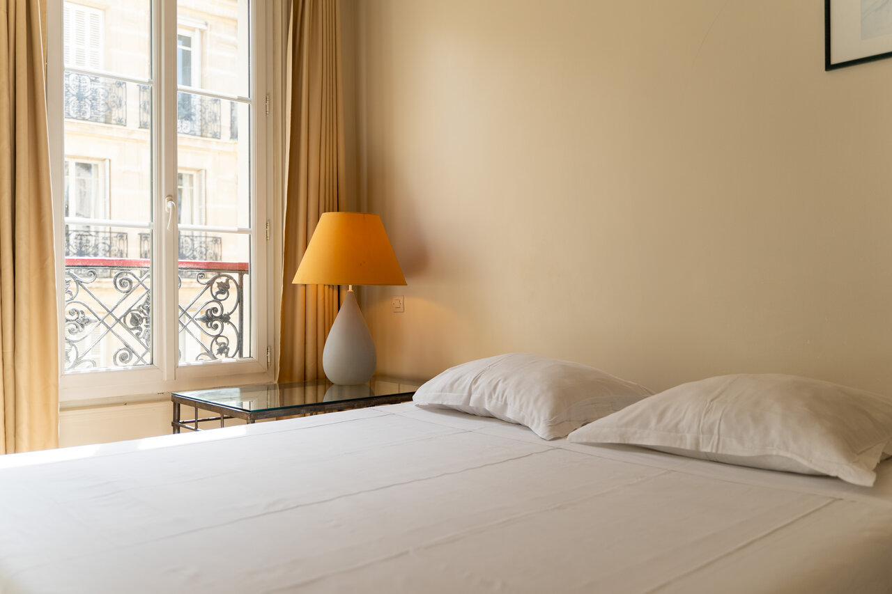 Habitaci�n doble c�moda con cama blanca y ventana, en el camping CAPFUN Hotel Paris Saint Germain en PAR�S (75).
