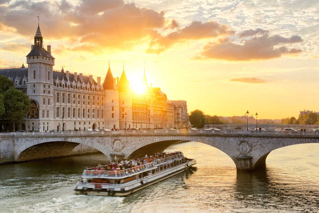 Barco tur�stico en el Sena, Conciergerie y Pont Neuf al atardecer en Par�s.