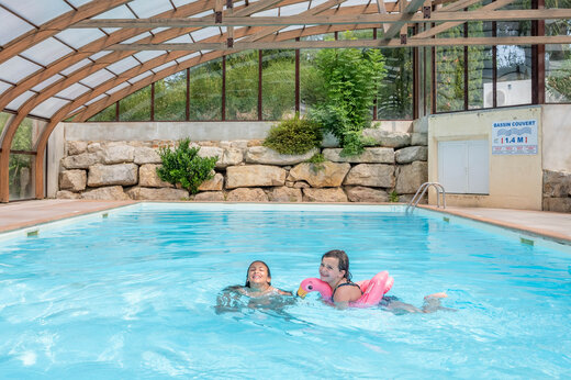 Piscina cubierta, ni�os jugando con flotador en camping CAPFUN Pergola en Marigny (39).