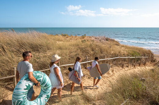 Familia en camino de arena hacia la playa en el camping CLICOCHIC Petit Bec en St Hilaire de Riez (85).
