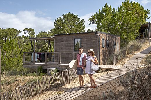 Mobil-home de madera, pareja en camino arenoso en el camping CLICOCHIC Petit Bec en St Hilaire de Riez.