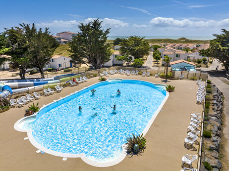 Piscina exterior, toboganes acuáticos y sillas en el camping CLICOCHIC Petit Bec en St Hilaire de Riez (85).