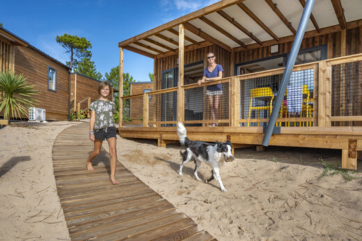 Mobil-home de madera con terraza y camino de arena en CLICOCHIC Petit Bec, St Hilaire de Riez.