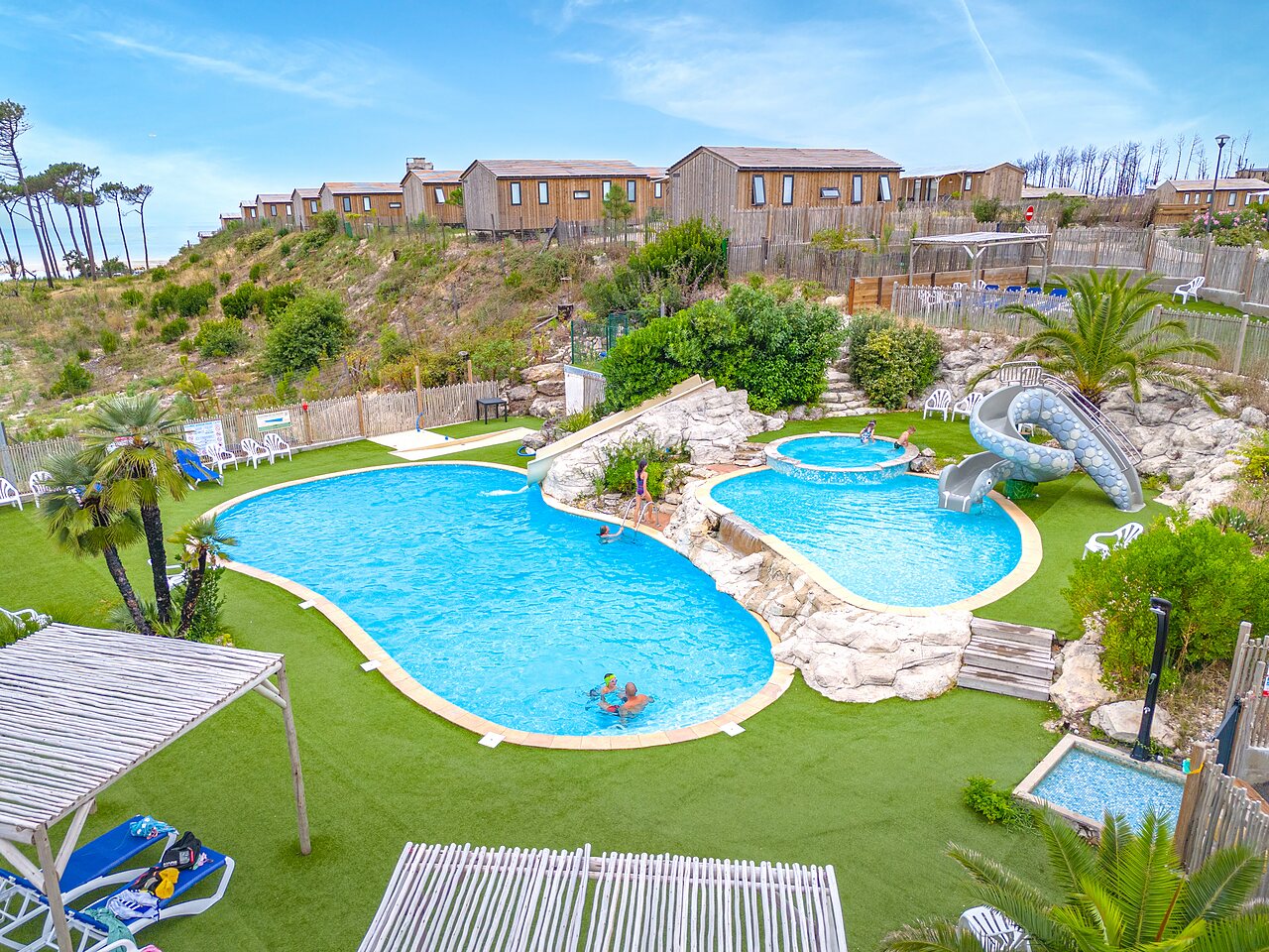 Piscina exterior, toboganes y jacuzzis en el camping CLICOCHIC Petit Nice en PYLA SUR MER.