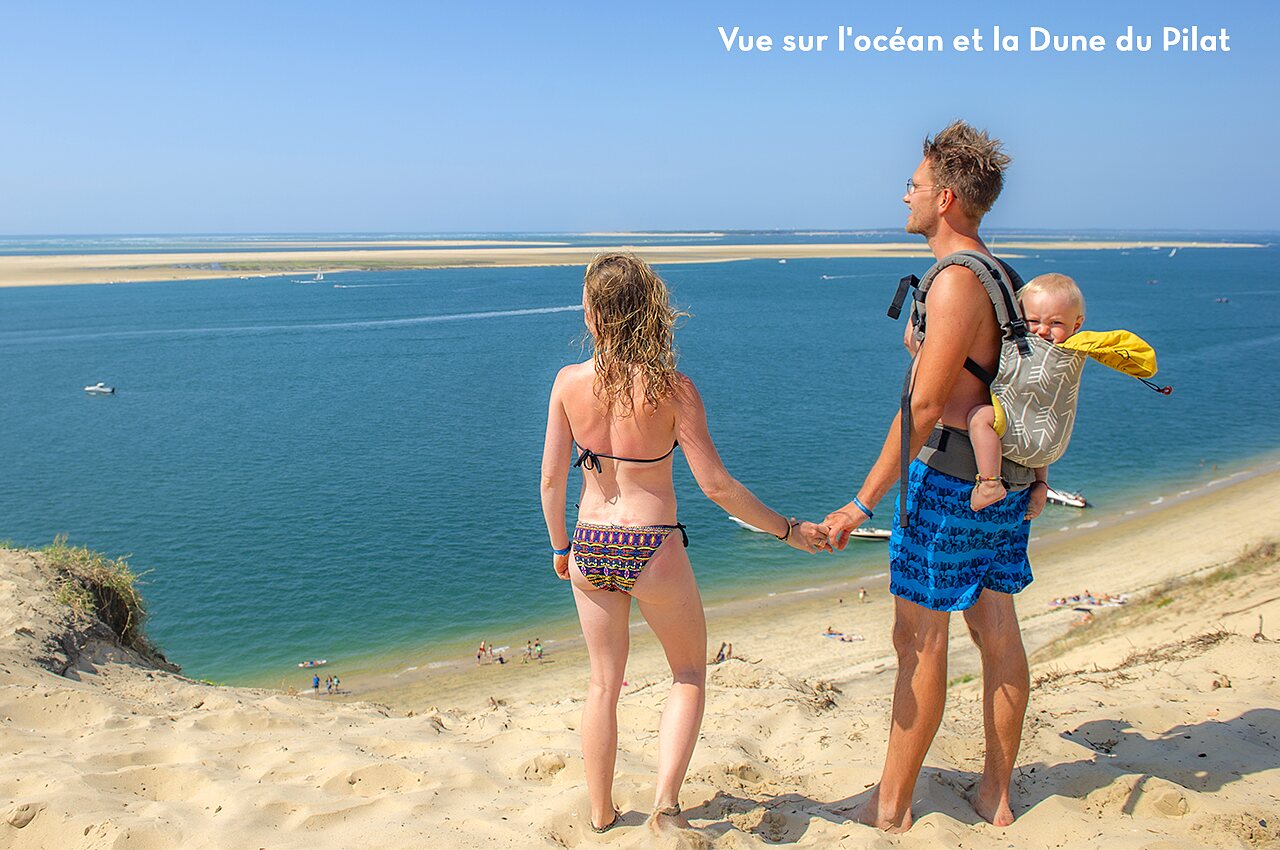 Pareja con beb� admirando la vista del Bassin d'Arcachon desde la Duna del Pilat, lugar para visitar cerca del camping.