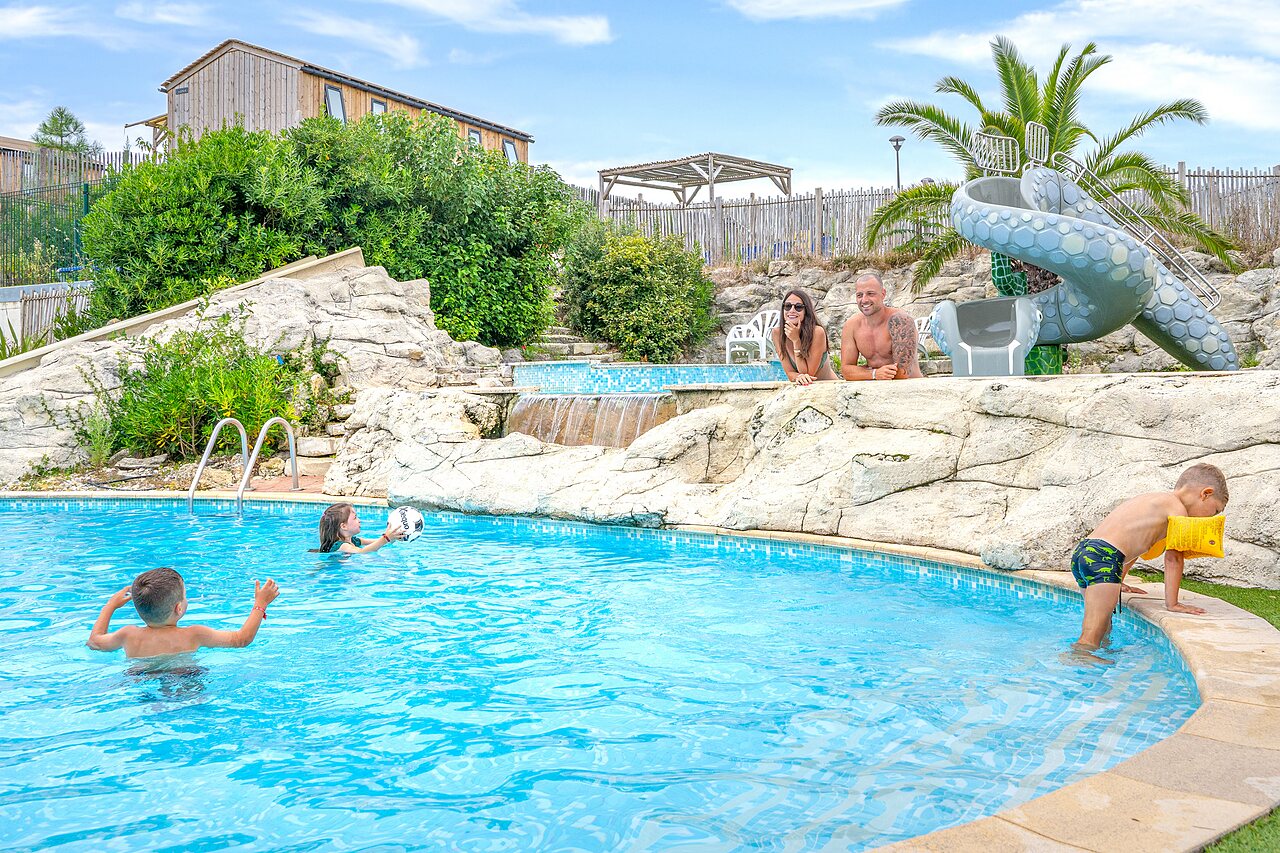 Familia disfrutando de la piscina con tobog�n y cascadas en el camping CLICOCHIC Petit Nice en PYLA SUR MER (33).