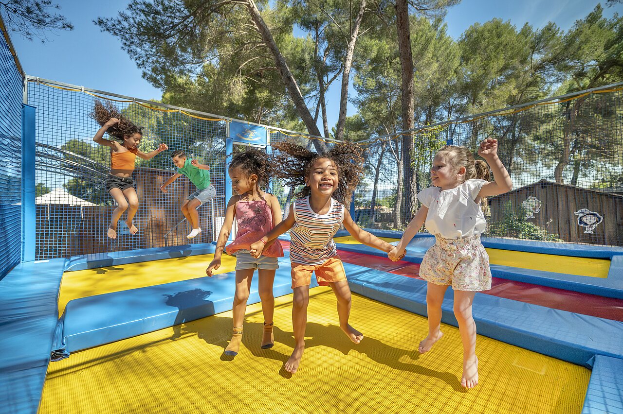Ni�os divirti�ndose en trampolines seguros en el camping CAPFUN Pin�des du Luberon en PERTUIS.