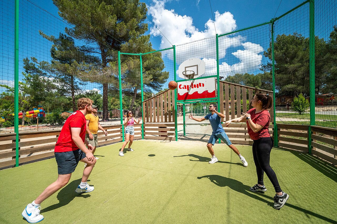 Cancha multideporte, amigos juegan baloncesto en camping CAPFUN Pin�des du Luberon (84).