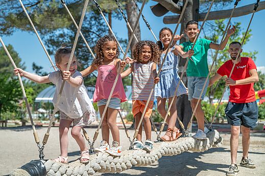 Niños y animador jugando en un puente de cuerda en el camping CAPFUN Pinèdes del Luberon en PERTUIS (84).
