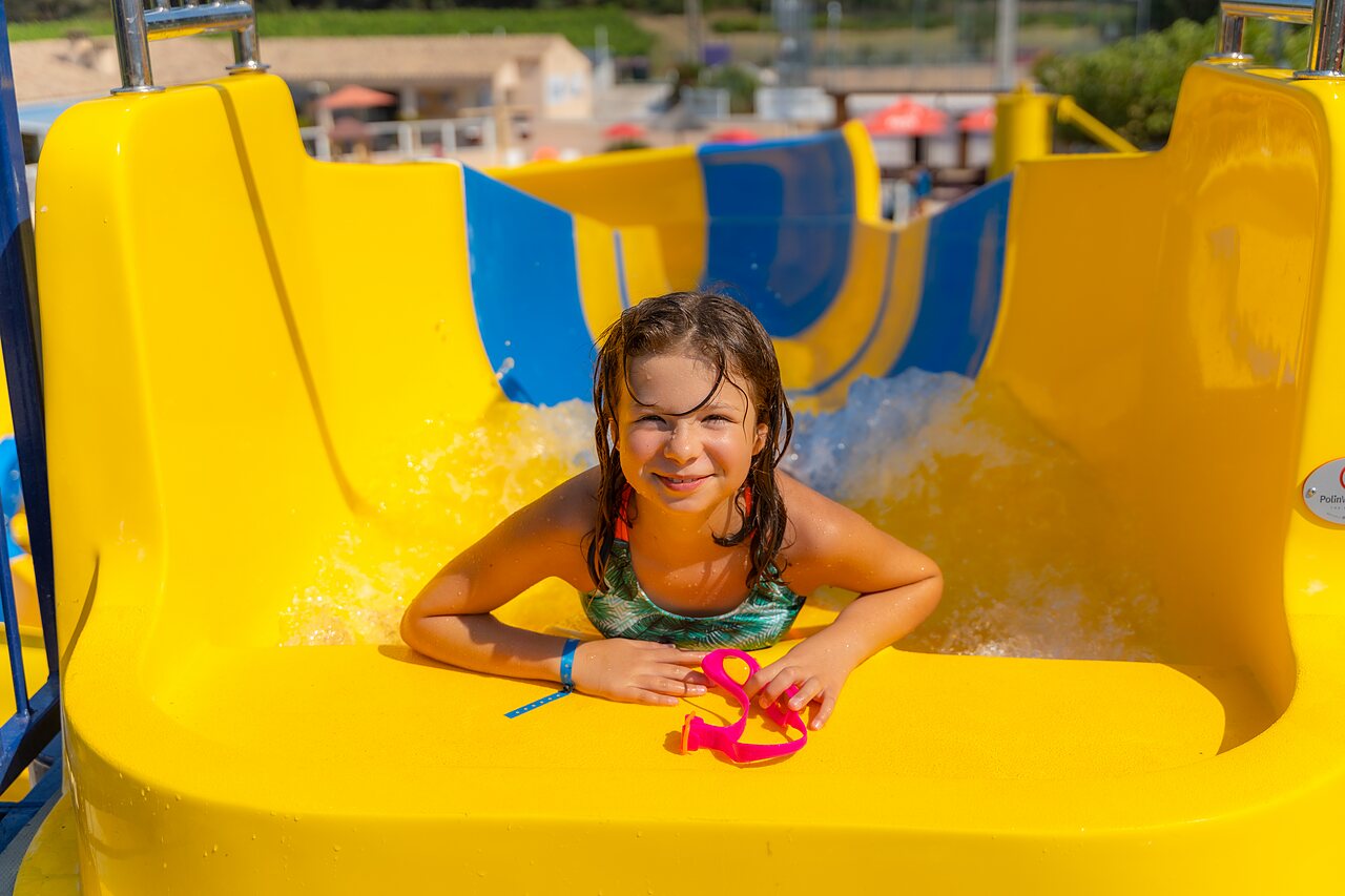 Ni�a sonriente en tobog�n amarillo en el camping CAPFUN La Pin�de de Grimaud (83).