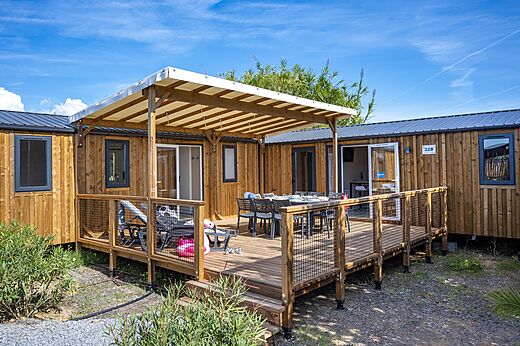 Mobil-home con terraza y mesa en el camping CAPFUN La Pinède de Grimaud.