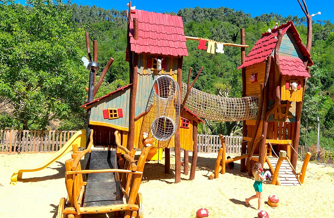 Zona de juegos de madera con toboganes y redes en el camping CAPFUN Plantas en SAINT VINCENT DE DURFORT.