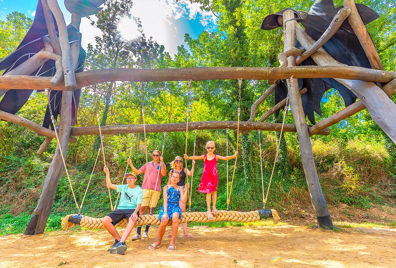 Familia divirti�ndose en columpio gigante en camping CAPFUN Plantas, SAINT VINCENT DE DURFORT.