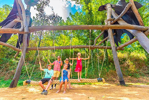 Gran columpio de madera original con una familia en el camping CAPFUN Plantas en SAINT VINCENT DE DURFORT (07).