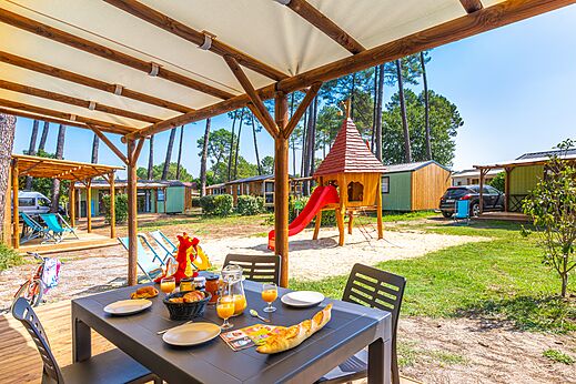 Casita de juegos y terraza de Mobil-home en el camping CAPFUN Pomme de Pin en Saubion.