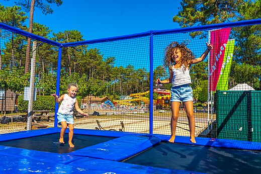 Ni�os saltando en trampol�n gigante en camping CAPFUN Pomme de Pin Saubion.