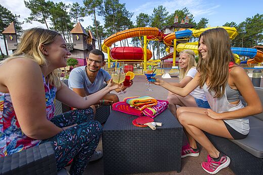 Amigos disfrutando c�cteles cerca de toboganes acu�ticos, camping CAPFUN Pomme de Pin Saubion (40).
