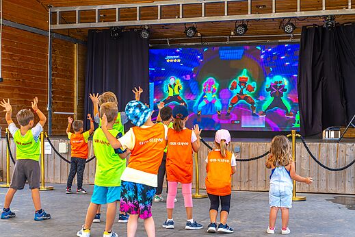 Ni�os disfrutando de animaci�n interactiva en pantalla grande en el camping CAPFUN Pomme de Pin en Saubion (40).