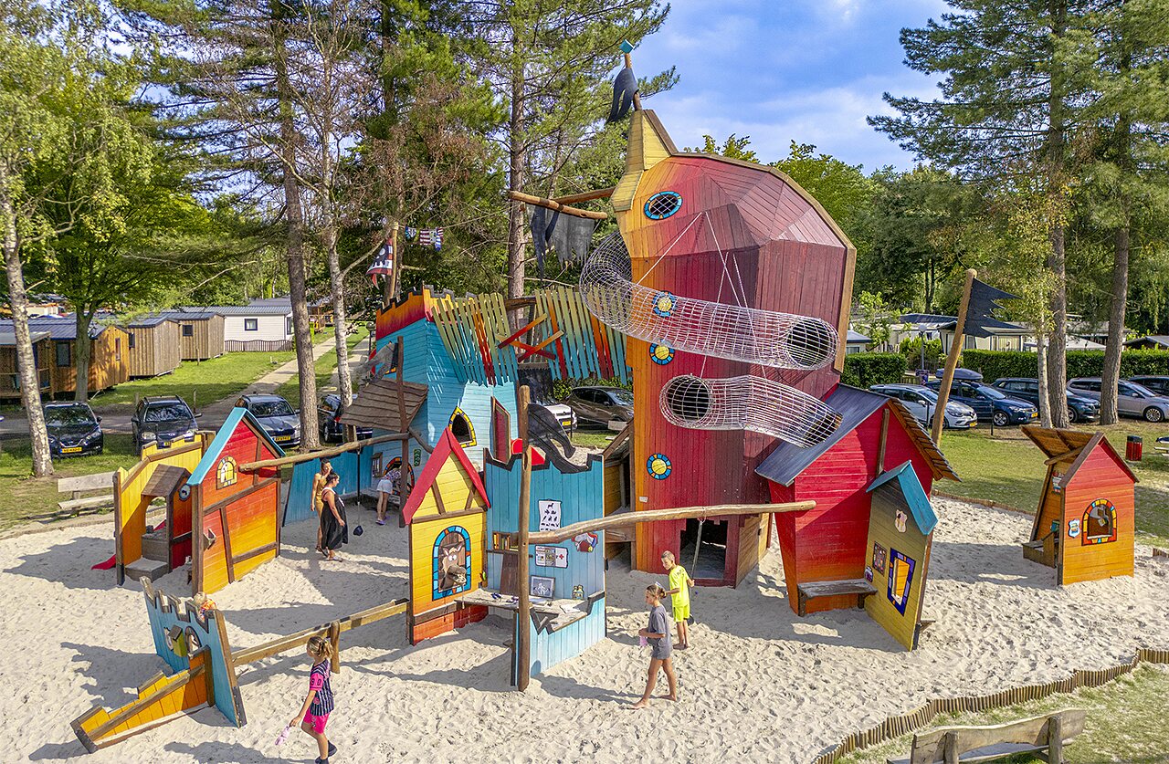 Gran parque infantil colorido con toboganes y ni�os en el camping CAPFUN Ponderosa en Ulicoten.