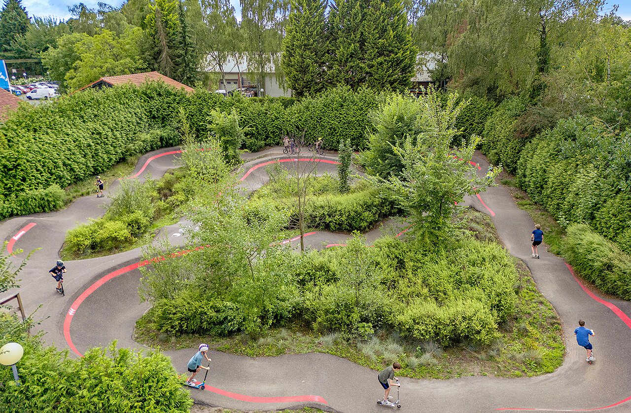 Ni�os en pumptrack con patinetes y bicicletas en el camping CAPFUN Ponderosa en Ulicoten.
