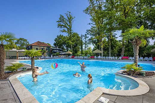 Piscina exterior familiar, jugando con balón, palmeras, camping CAPFUN Ponderosa, Ulicoten.