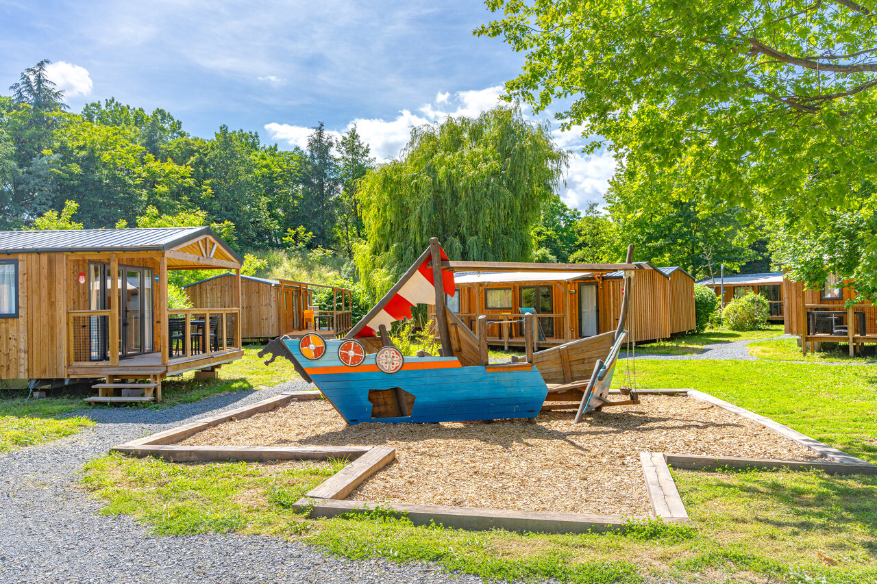 Zona de juegos barco vikingo y Mobil-homes en el camping CAPFUN Les Portes du Beaujolais en Anse (69).