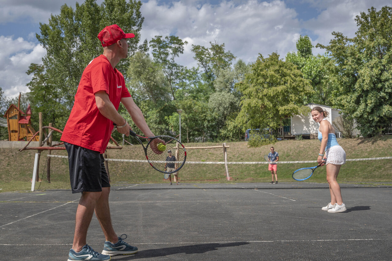 Cancha de tenis, zona de juegos en el camping CAPFUN Les Portes du Beaujolais en Anse (69).