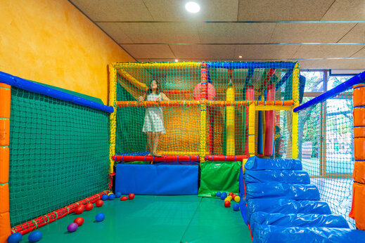 Zona de juegos interior colorida con niño en el camping CAPFUN Serra de Prades en Vilanova de Prades (43)